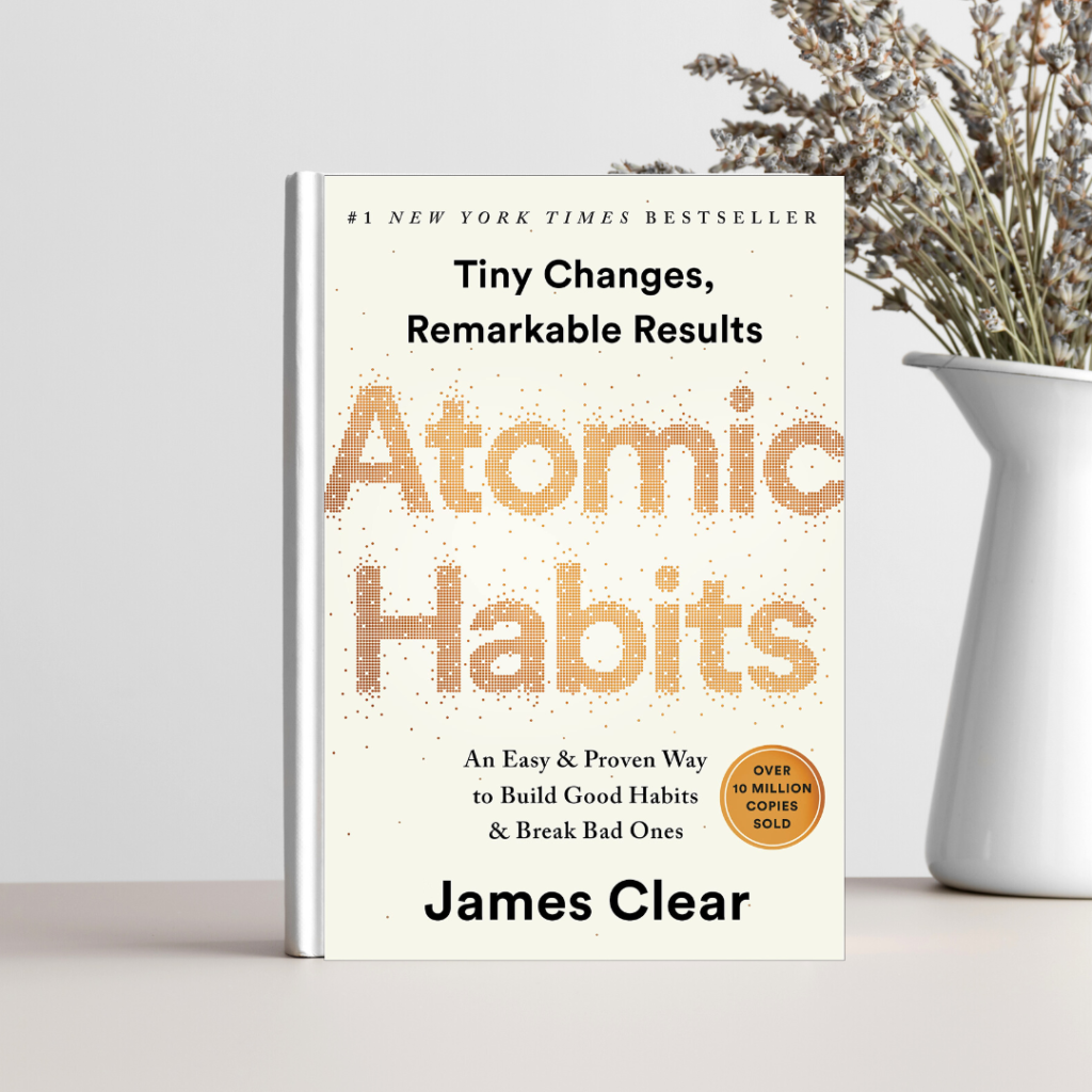 A picture of the book atomic habits next to a decorative vase.